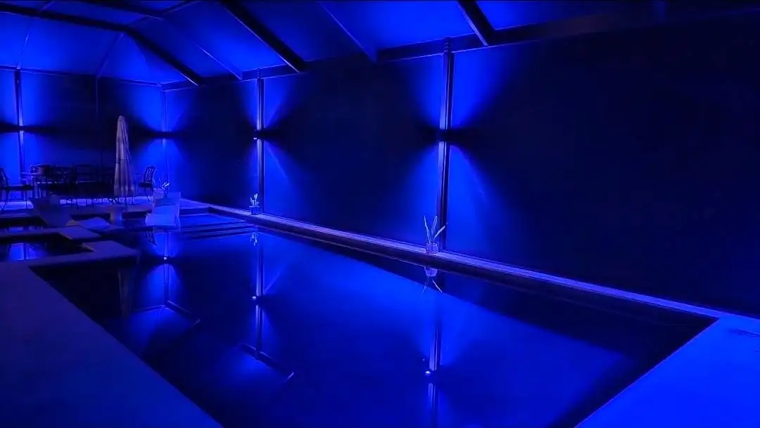 A screen pool enclosure lit deep blue at night