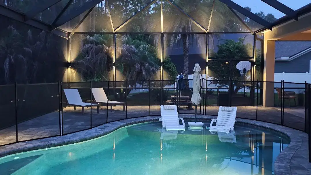 Warm white across a screen enclosure, loungers and palms lit